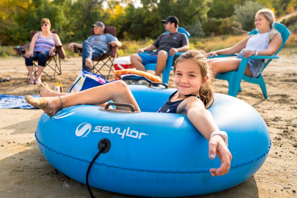 Girl on a blue tube at the lake.